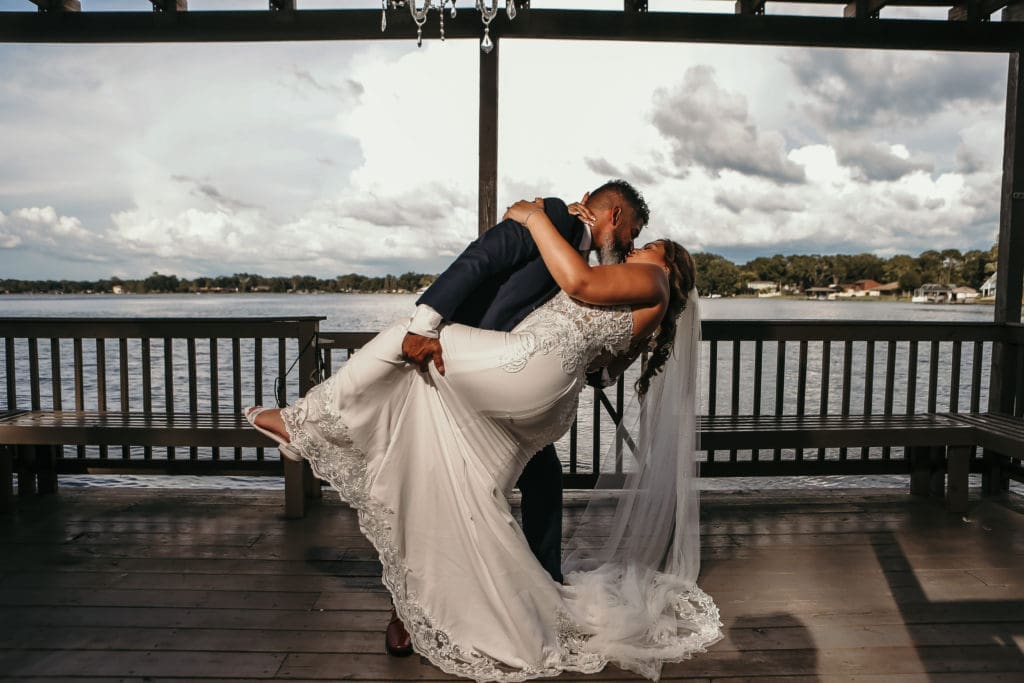 Couple kissing on dock at Knotted Roots on the Lake