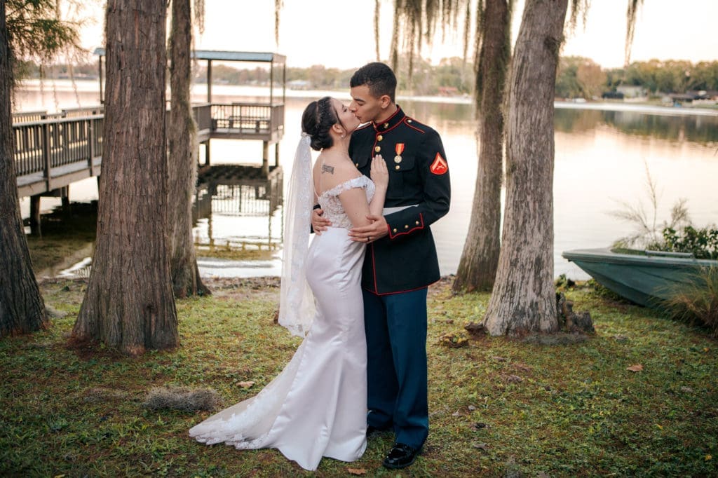 Bride and Groom Kissing in front of Lake Padgett at Knotted Roots on the Lake