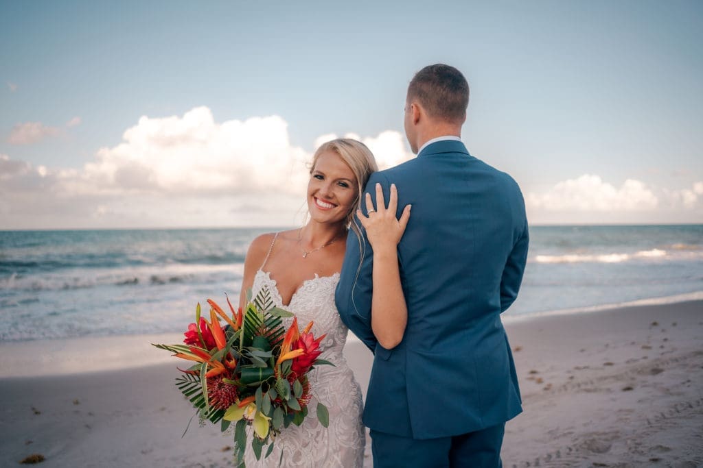 Bride holding groom on beach at at Kimpton Vero Beach Hotel & Spa