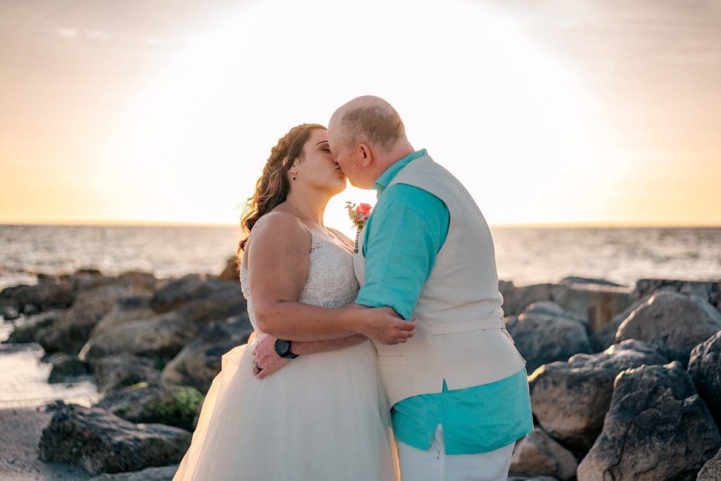 Bride and Groom kissing on beach at Sunset Beach, Treasure Island