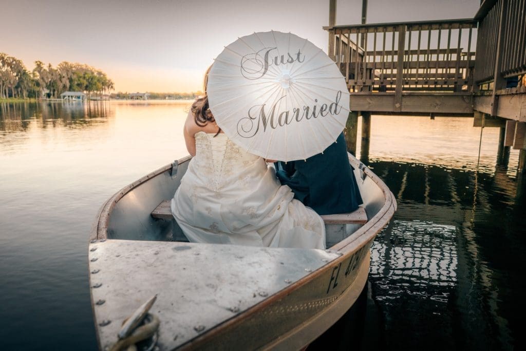 Just married umbrella on boat at Knotted Roots on the Lake