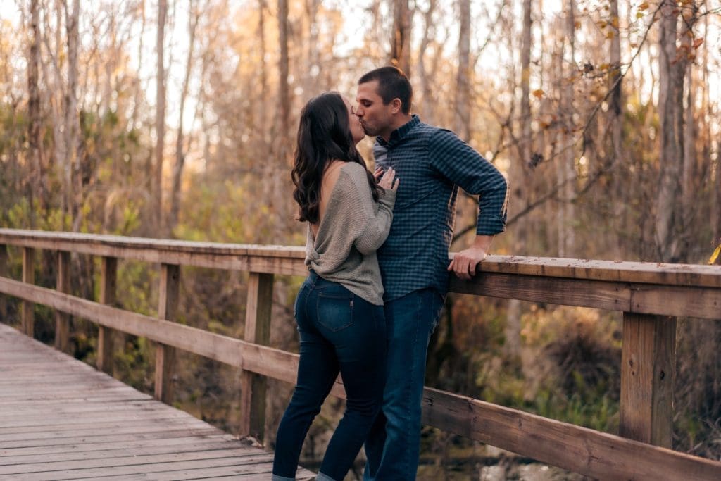 Engaged couple kissing on Florida trail