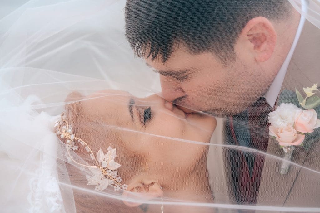 Bride kissing groom under veil at MacDill Air Force Base