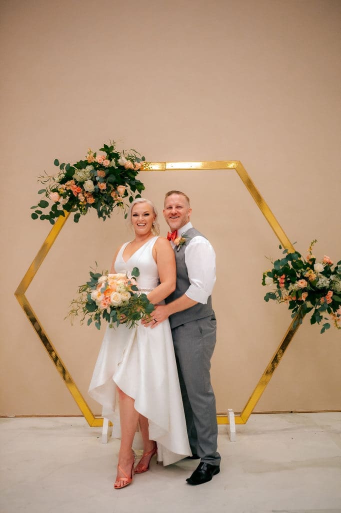 Bride and groom in from of arch at DoveCote Wedding - Orlando
