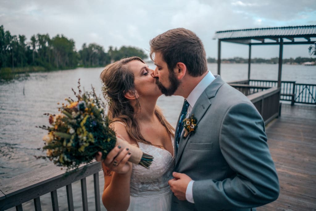 Bride and Groom kissing on dock at Knotted Roots on the Lake - Land O' Lakes