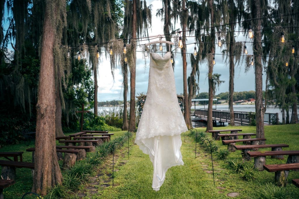 Wedding Dress hanging on market lights at Knotted Roots on the Lake - Land O' Lakes