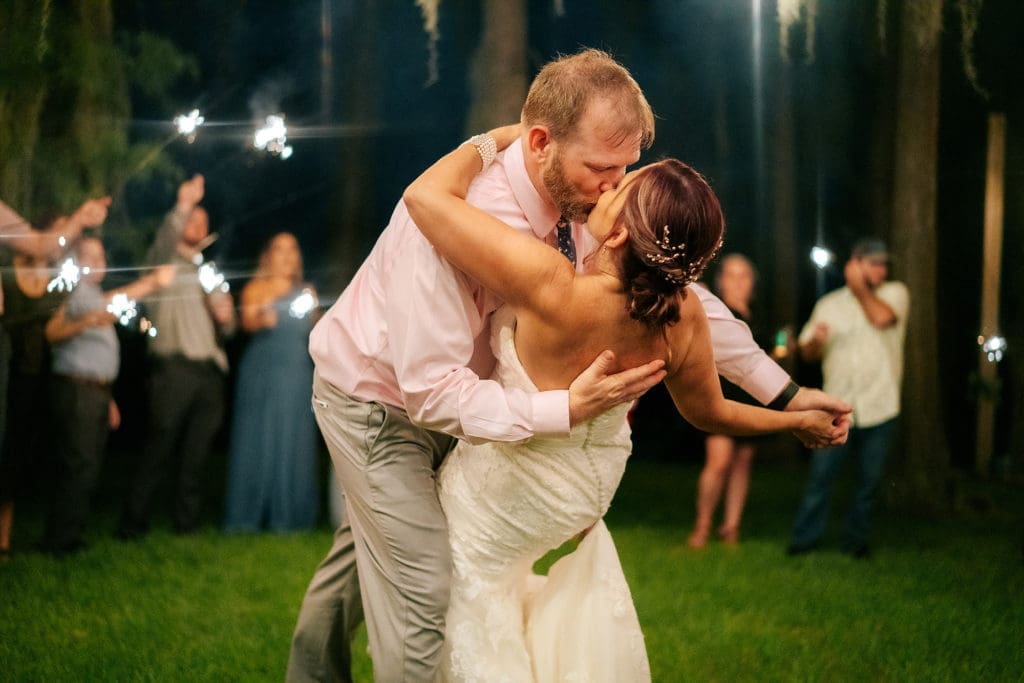 Groom dipping bride during sparkler dance at Knotted Roots on the Lake - Land O' Lakes