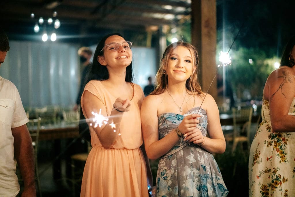 Wedding guests holding sparklers at Knotted Roots on the Lake - Land O' Lakes