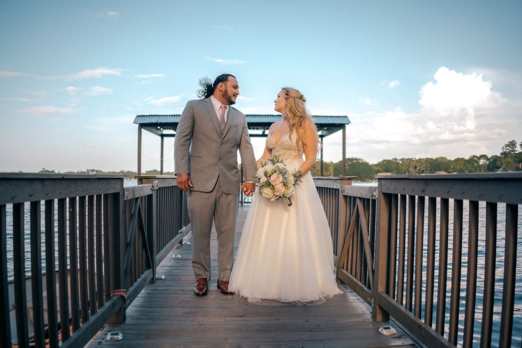 Bride and groom standing on dock at Knotted Roots on the Lake