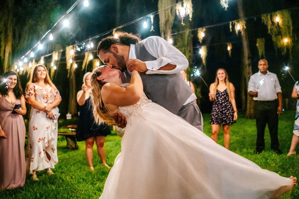 Groom dipping bride during sparkler dance at Knotted Roots on the Lake