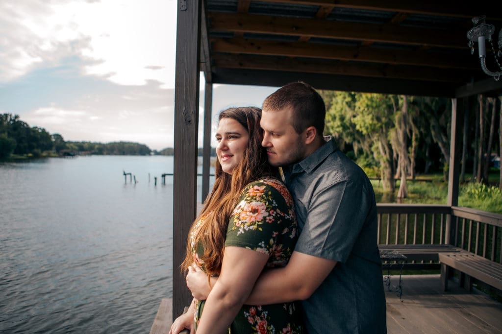 Engaged couple holding each other on dock at Knotted Roots on the Lake